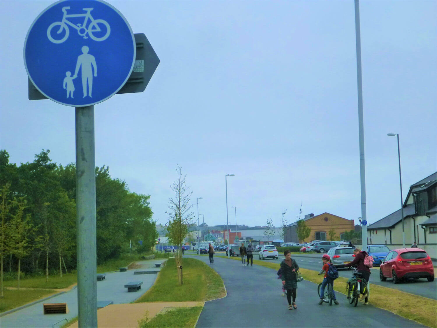 A signpost with a bicycle and a parent and toddler holding hands